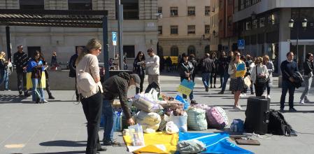 Un hombre deposita dinero en la urna situada en la plaza de la Montanyeta de Alicante, uno de los puntos donde los residentes ucranianos recogen ayuda para su país.