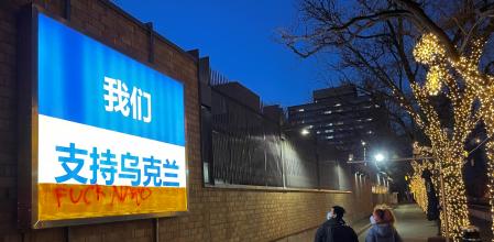 Cartel en apoyo a Ucrania frente a la invasión rusa con un grafiti contra la OTAN en la embajada canadiense en Beijing