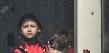 Children look out of a train window at the Medyka border crossing at the Polish-Ukrainian border, southeastern Poland on March 12, 2022. - More than two and a half million people have fled the 