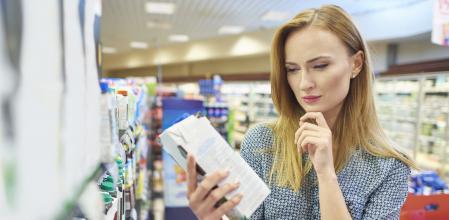 Mujer leyendo los componentes de una marca de leche