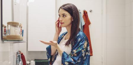 Mujer embarazada echándose una loción