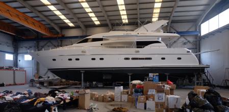 Ante uno de los yates que espera reparación, la empresa hace acopio de la ayuda que llega a diario y es trasladada a la frontera de Ucrania mediante camiones.