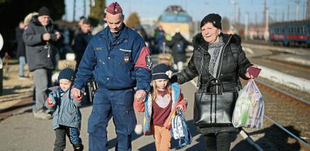 ZAHONY, HUNGARY - MARCH 12: A Hungarian police officer helps families as they arrive at Zahony train station after fleeing Ukraine on March 12, 2022 in Zahony, Hungary. More than 2 million refugees have fled Ukraine since the start of Russia's military offensive, according to the UN. Hungary, one of Ukraine's neighbouring countries, has welcomed more than 144,000 refugees fleeing Ukraine after Russia began a large-scale attack. on March 12, 2022 in Zahony, Hungary. More than 2 million refugees have fled Ukraine since the start of Russia's military offensive, according to the UN. Hungary, one of Ukraine's neighbouring countries, has welcomed more than 144,000 refugees fleeing Ukraine after Russia began a large-scale attack. (Photo by Christopher Furlong/Getty Images)
