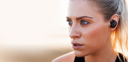 Mujer llevando los auriculares Bose Sport Earbuds