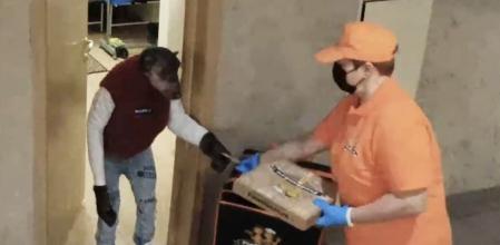 Una repartidora va a entregar una pizza y la recibe un chimpancé en la puerta con el dinero