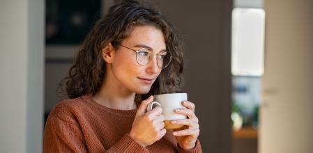 Una mujer toma una infusión en su casa