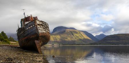 Un barco abandonado y el Ben Nevis como telón de fondo