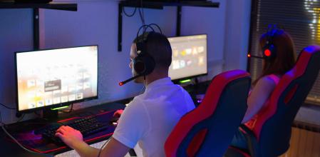 Dos personas jugando en el PC sentados en sillas gaming