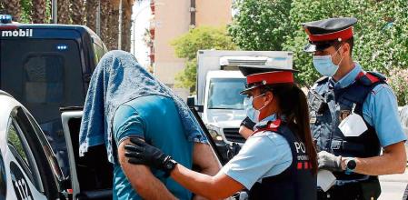 GRAFCAT9556. BARCELONA, 14/07/2020.- Mossos d'esquadra custodian a uno de los detenidos en la operación contra el terrorismo yihadista que llevan a cabo desde primera hora de la mañana en el distrito de Ciutat Vella de Barcelona. EFE/Toni Albir