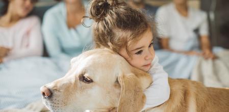Niña abrazando a un perro