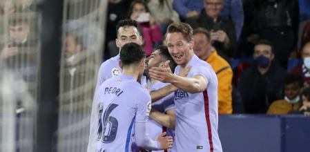 Barcelona's Luuk de Jong, right, celebrates after scoring his side's third goal during a Spanish La Liga soccer match between Levante and Barcelona at the Ciutat de Valencia stadium in Valencia, Spain, Sunday, April 10, 2022. (AP Photo/Alberto Saiz)