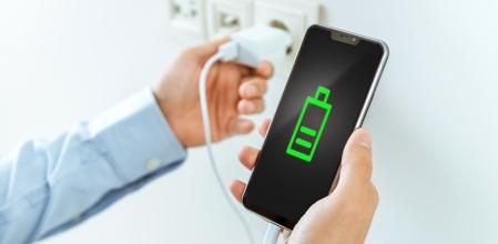 Un hombre carga su smartphone