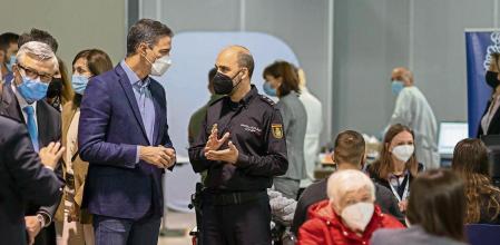 MÁLAGA, 20/04/2022.-El presidente del Gobierno Pedro Sánchez(i) conversa con un agente de la Policía Nacional durante su visita al centro de refugiados habilitado en Málaga, para la recepción, atención y derivación de ciudadanos ucranianos que huyen de la invasión rusa de Ucrania. EFE/Carlos Díaz