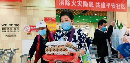People shop at a supermarket in Beijing on April 25, 2022. (Photo by WANG Zhao / AFP)
