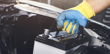 Un mecánico reemplaza la batería de un coche