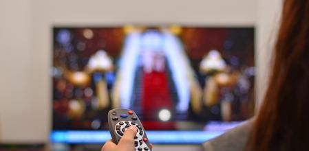 Una mujer utiliza el mando a distancia de la tele