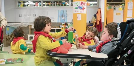 Escuela inclusiva, Aleix de tres años no tiene movilidad muscular , en su clase de tortugas de p-3 esperando antes de una excuersión mientras una compañera le atiende y juega con él, el resto de niños se desviven po él y han tenido que establecer turnos para que no se peleen.. Foto Ana Jiménez