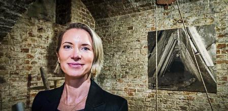 La periodista británica Helena Merriman, autora del libro 'El túnel 29. Crónica de una extraordinaria fuga bajo el Muro de Berlín', fotografiada en Berlín el 25 de abril a la entrada de una réplica del túnel en el mismo lugar (el túnel original fue cegado por la policía de fronteras de la RDA)