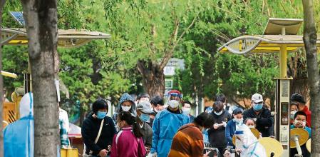BEIJING, CHINA - APRIL 29: People wait in line for a swab test at a COVID-19 test site on April 29, 2022 in Beijing, China. China is trying to contain a spike in coronavirus cases in capital Beijing, after dozens of people tested positive for the virus in recent days. Local authorities have initiated mass testing in most districts and locked down some neighbourhoods where cases are found in an effort to maintain the country's zero COVID strategy. (Photo by Lintao Zhang/Getty Images)