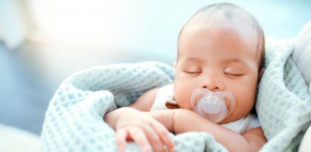 Bebé durmiendo en brazos de su madre