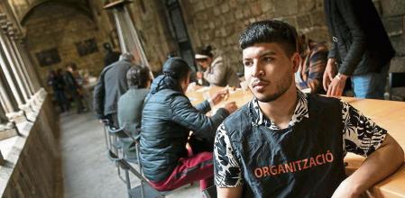 Reparto de desayunos a personas sin techo en la Capilla de Santa Anna. Jóvenes migrantes menores de 23 .Migrantes, personas sin hogar,sin techo, homeless