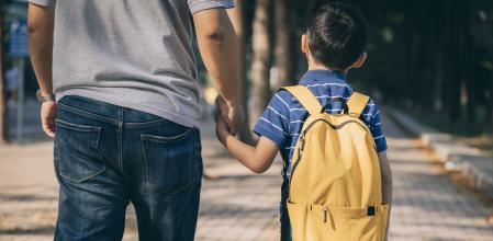 Un padre acompañando a su hijo al colegio