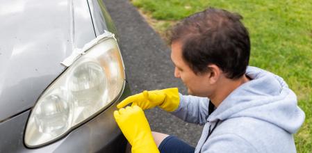 Un hombre se afana en mantener los faros de su coche