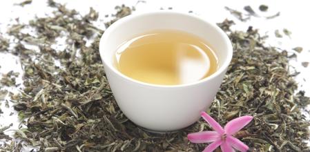 Té blanco junto a las hojas que le dan el sabor