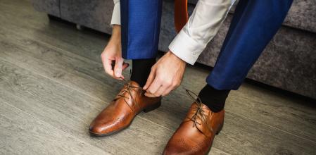 Un hombre atándose zapatos de piel