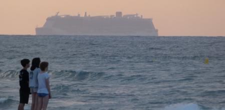 Expectación ante el paso de un gran crucero en la playa de Gavà.