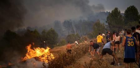 Vecinos colaboran en las labores de extinción en un incendio forestal, a 17 de julio de 2022, vistas desde Sant Fruitós del Bages, Barcelona, Cataluña, (España). El fuego se ha iniciado hoy domingo a medio día y ya afecta a 95 hectáreas, en su extinción trabajan 81 dotaciones de los Bombers de la Generalitat, de las cuales 13 son aéreas. El fuego, avivado por el viento del sur, avanza 