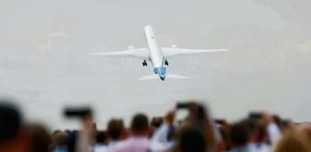 Attendees watch a Boeing 777X aircraft during a display at the Farnborough International Airshow, in Farnborough, Britain, July 20, 2022. REUTERS/Peter Cziborra