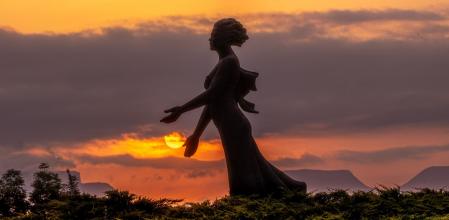 Amanecer con la escultura de 'La Benvinguda' de Manlleu en primer plano.