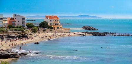 Bird's eye view of the tip of Cap d'Agde. Mixture of rocks, sunny buildings on a sea background.