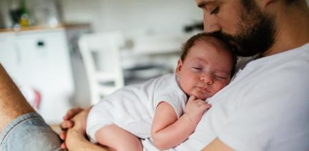 Father holding his baby boy who is falling asleep