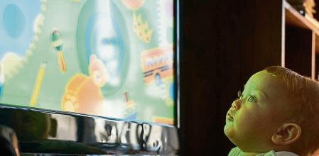 Side View Of Cute Baby Boy Watching Tv At Home - Fotografía de stock