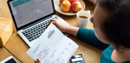 Mujer frente ordenador y factura