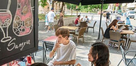 Jóvenes estudiantes fumando en una terraza del centro de Barcelona