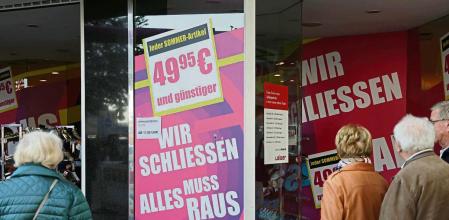 BERLIN, GERMANY - SEPTEMBER 30: People pause at a shoe store that will be closing soon and is advertising hefty discounts on September 30, 2022 in Berlin, Germany. Inflation in Germany reached 10% in September compared to one year ago, its biggest jump since 1951. Meanwhile leading economists are expecting the German economy to slip into recession within the next year. Both woes have been brought on mainly by skyrocketing energy prices due to consequences stemming from Russia's ongoing war in Ukraine. (Photo by Sean Gallup/Getty Images)