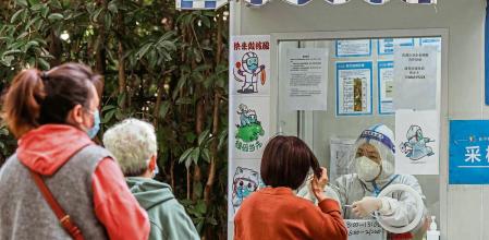 Shanghai (China), 10/10/2022.- People take Coronavirus PCR test in front of the quarantined area amid new Covid-19 lockdown in Shanghai, China, 10 October 2022. In Shanghai, there are 3 locally transmitted COVID-19 cases and 31 local asymptomatic infections, according to the Shanghai Health Commission report on 10 October. Multiple residential communities have been put under lockdown following rising cases during the 7-day holiday to celebrate National Day. EFE/EPA/ALEX PLAVEVSKI