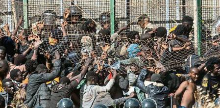 Migrants arrive on Spanish ground after crossing the fences separating the Spanish enclave of Melilla from Morocco in Melilla, Spain, Friday, June 24, 2022. Dozens of migrants stormed the border crossing between Morocco and the Spanish enclave city of Melilla on Friday in what is the first such incursion since Spain and Morocco mended diplomatic relations last month. (AP Photo/Javier Bernardo)