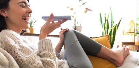 Young happy caucasian woman using smartphone to send voice message. Technology concept.