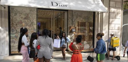 COLAS EN LAS TIENDAS DE LUJO DE PASSEIG DE GRACIA. UN GRUPO DE JOVENES TURISTAS AMERICANAS SE HACEN UNA FOTO JUNTO A LA PUERTA DE DIOR TRAS HACER UNA COMPRA EN LA TIENDA