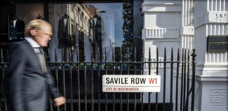 Un transeúnte, vestido con traje, en la tradicional calle de las sastrerías