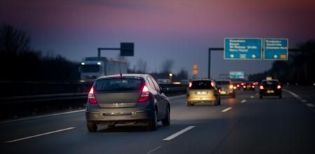 Coches circulando por una autopista al atardecer 