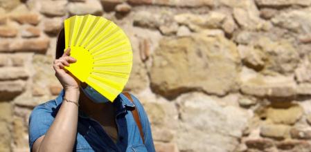 GRAF470. CÓRDOBA, 06/09/2020.- Una mujer protegida con mascarilla se protege del sol con un abanico para aliviar el calor ante la subida de las temperaturas. Las temperaturas permanecerán hoy en Andalucía con pocos cambios con respecto a las de ayer, según la predicción de la Agencia Estatal de Meteorología (Aemet). EFE/Salas