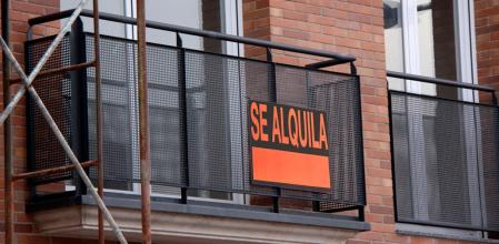 Un cartel anunciando un alquiler en el balcón de un piso