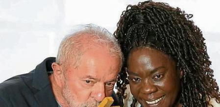Brazil's former President Luiz Inacio Lula da Silva, left, who is running for reelection, kisses a cross he received from Catholic nun Sister Rosa during a meeting with members of the Catholic Church, in Sao Paulo, Brazil, Monday, Oct. 17, 2022. Da Silva will face Brazilian President Jair Bolsonaro in a presidential runoff on Oct. 30. (AP Photo/Andre Penner)