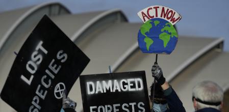 FILE - Demonstrators from Extinction Rebellion holds placards at a protest about Loss and Damage to the earth during the COP26 Climate Change conference in Glasgow, Scotland, Nov. 7, 2021. Once the world had hope that when nations got together they could stop climate change. Thirty years after leaders around the globe first got together to try, that hope has melted. (AP Photo/Alastair Grant, File)