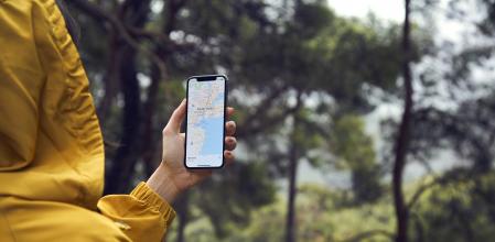 Istanbul, Turkey - January 25, 2019: Woman in the farm planning a route using a Google Maps application on Apple iPhone X. Google Maps is a most popular web mapping service for mobile provided by Google inc.